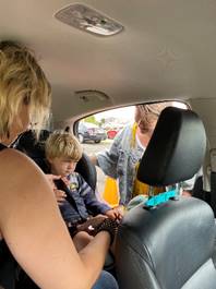 A person sitting in a car with a child in the back seat

Description automatically generated