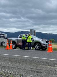 A group of people standing next to a truck

Description automatically generated