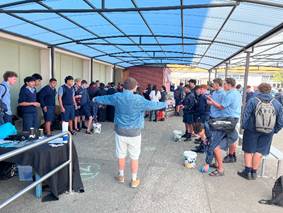 A group of people standing in a covered area

AI-generated content may be incorrect.