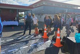 A group of people standing in a parking lot

AI-generated content may be incorrect.